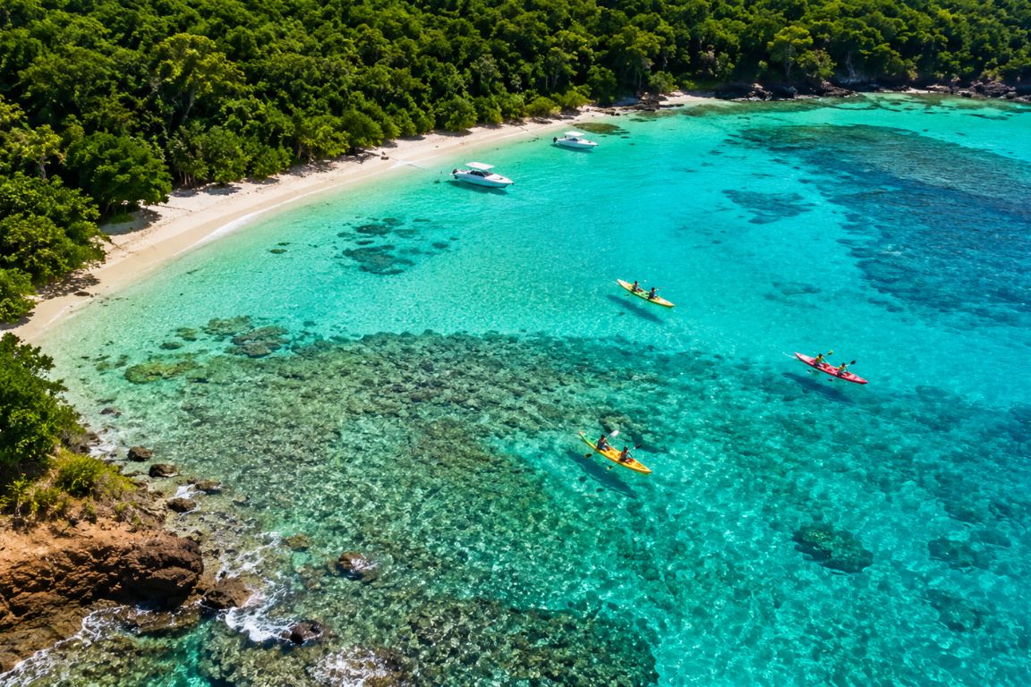 Aerial view of Luis Peña Channel Natural Reserve with crystal-clear turquoise waters, coral reefs, kayakers, and boats during a guided tour with Culebra Tours