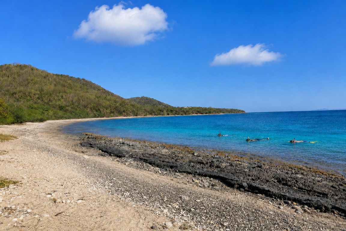 Visitors snorkeling in the clear turquoise waters of Tamarindo Beach during a guided beach and snorkeling tour with Culebra Tours
